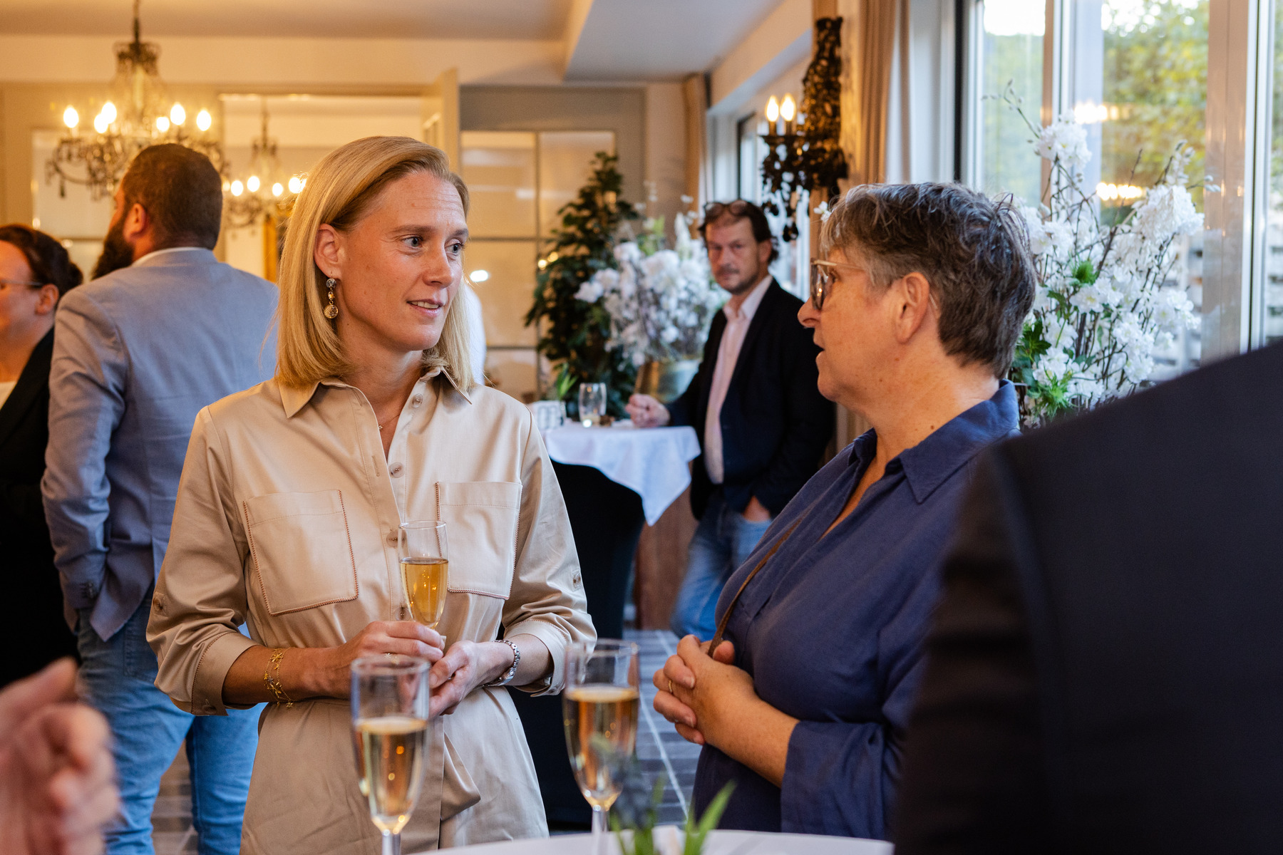 Een gesprek tussen twee gasten tijdens het horecafeest.